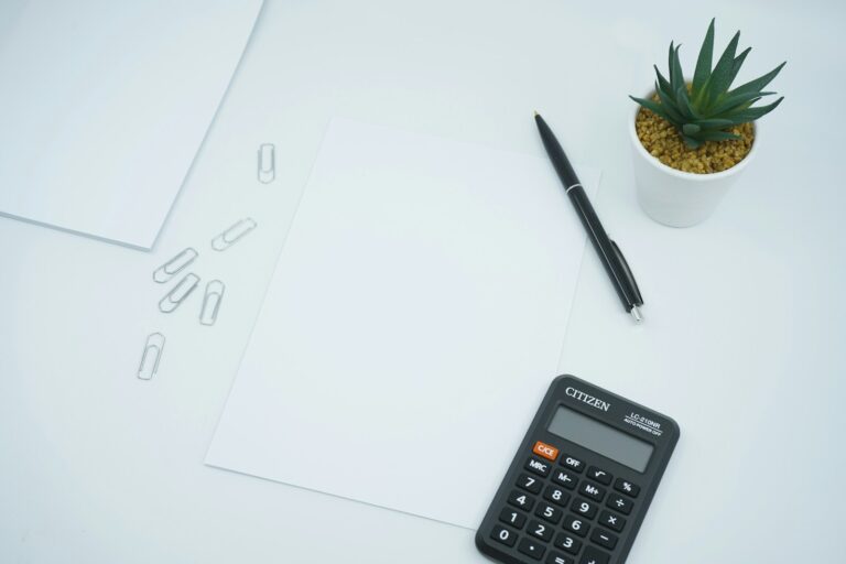 A calculator, pen, and blank notepad on a desk, illustrating how Atlanta bar, club, and hookah lounge owners estimate their 2026 insurance premiums and the factors that drive the number