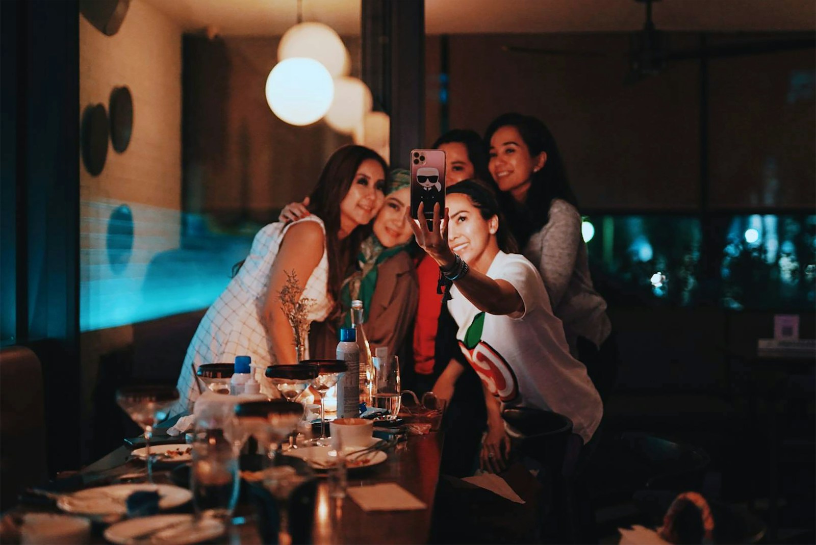 A group of patrons toasting cocktails at a busy late-night bar, illustrating the Georgia dram shop and liquor liability exposure Atlanta nightlife venues take on the moment they over-serve a guest