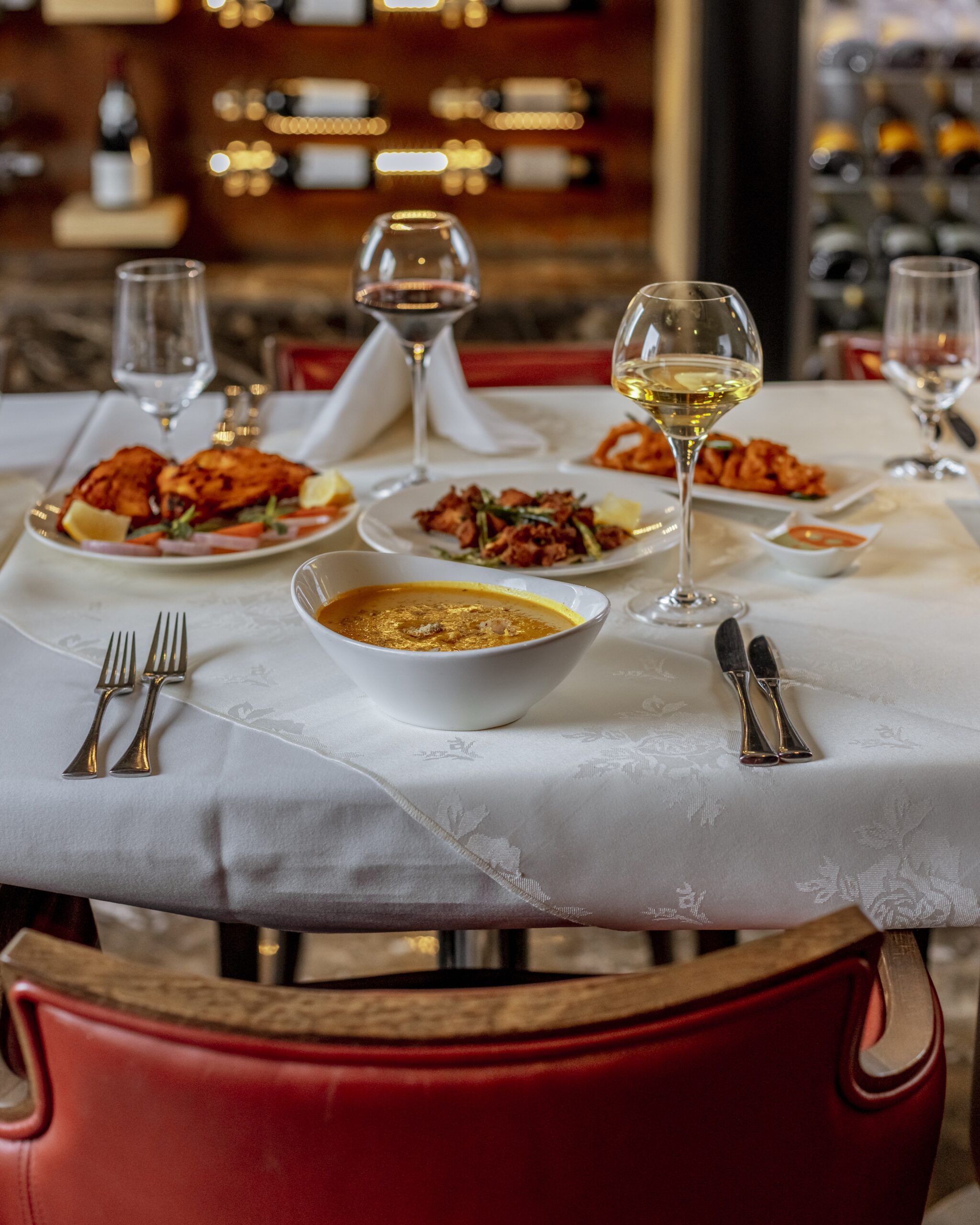 Elegant Atlanta restaurant table set with wine glasses and food, illustrating the liquor liability exposure that appears once a full-service restaurant adds a bar