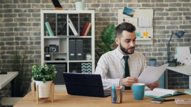 Business owner reading an insurance non-renewal notice at his desk and thinking through next steps