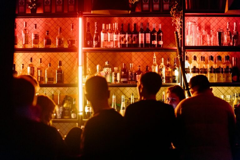 Busy bar interior at night with guests gathered around the counter