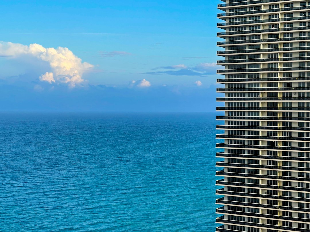 Coastal high-rise condominium building near the sea under a blue sky