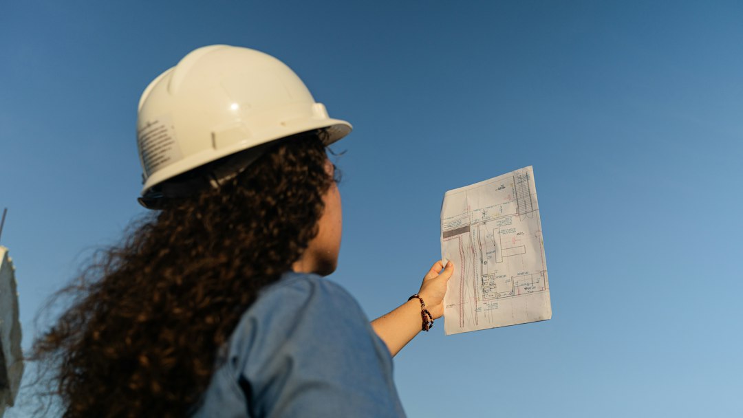 Contractor in a hard hat reviewing subcontract paperwork and insurance requirements on site