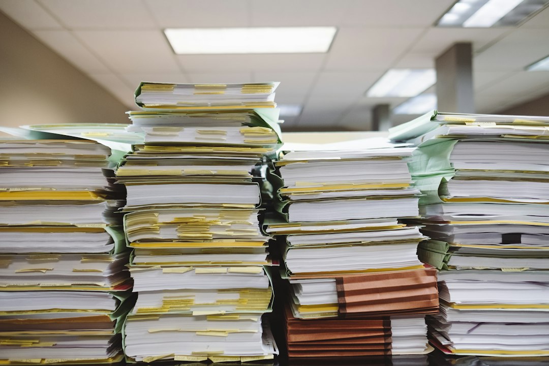Stacks of business documents and file folders, representing loss runs and underwriting information gathered for a remarketing submission