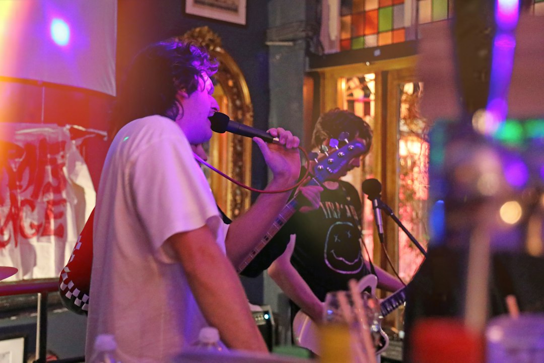 Musician singing and playing guitar on a small stage, representing live entertainment added to a restaurant