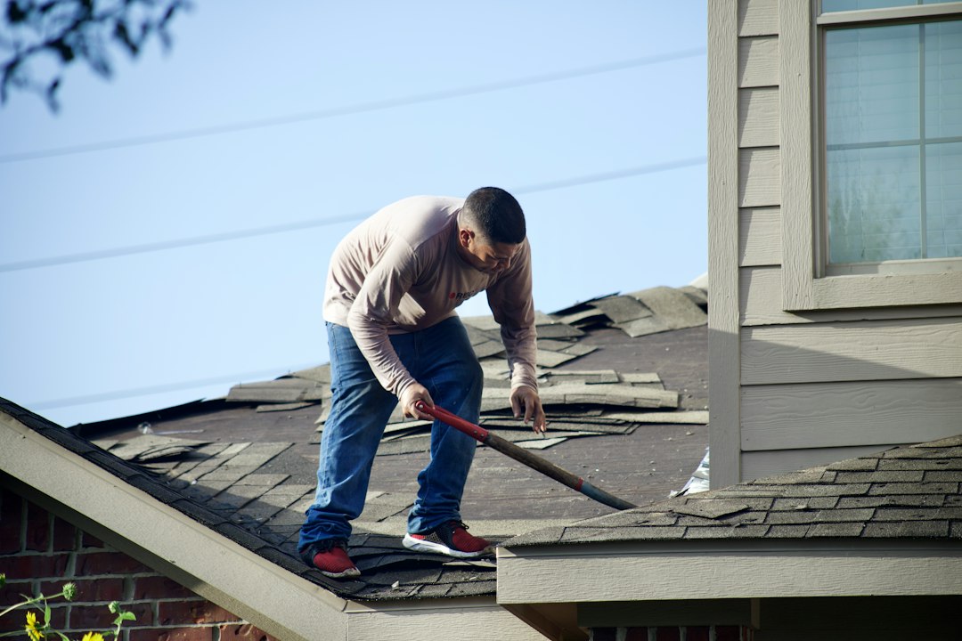 Roofer tearing off an old roof, a high-hazard trade for contractor insurance pricing