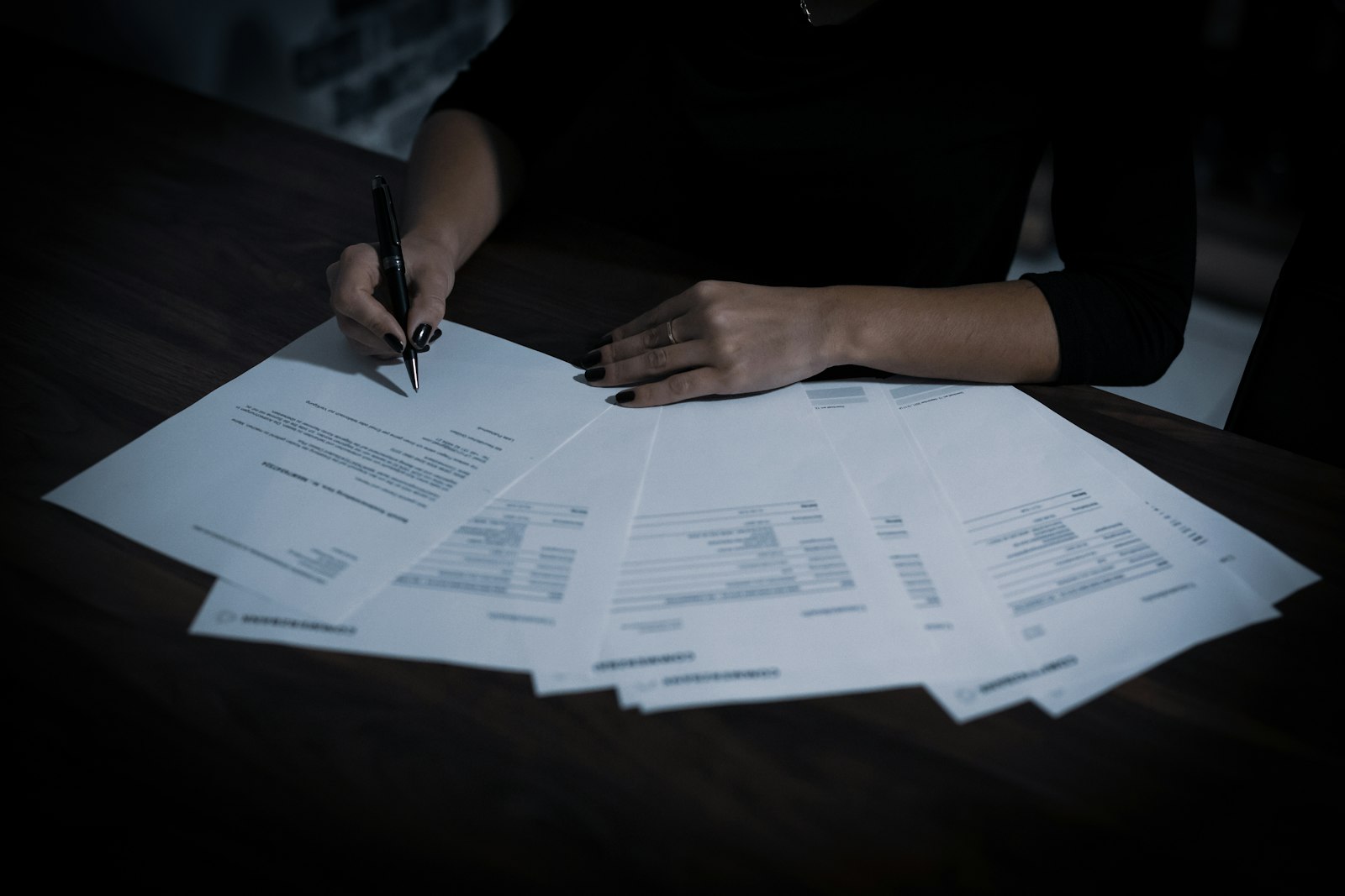 Executive signing a D&O insurance policy application with a ballpoint pen